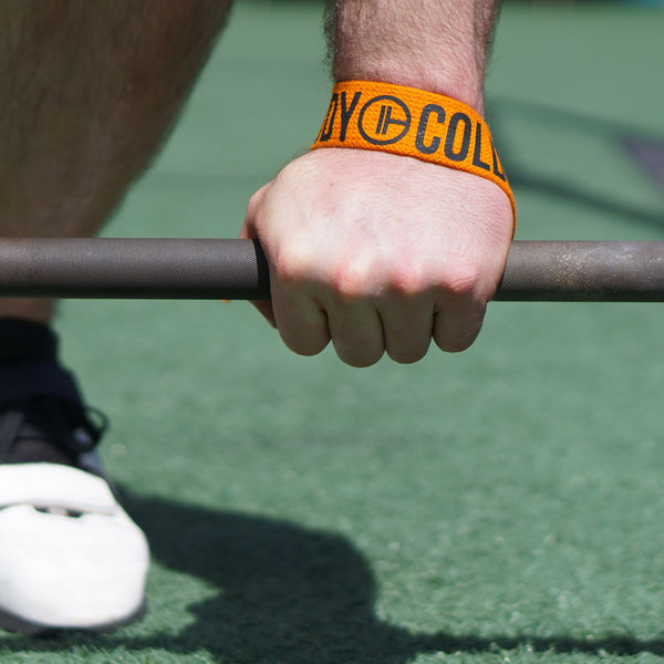 A man lifts the barbell using Orange Weight Lifting Wrist Straps V1