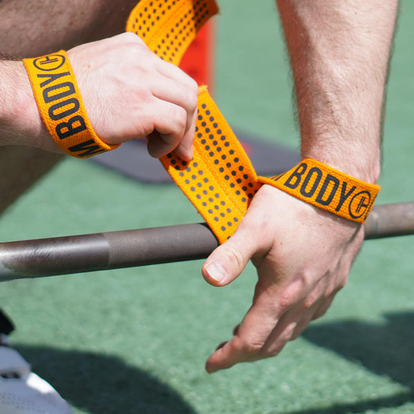 Manputs on Orange Weight Lifting Wrist Straps V1 to lift the barbell