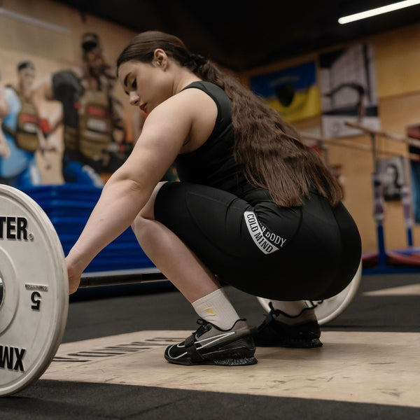 Person in WOMEN'S WEIGHTLIFTING COMPRESSION SINGLET S-4 performing a weightlifting exercise in a gym setting - Warm Body Cold Mind